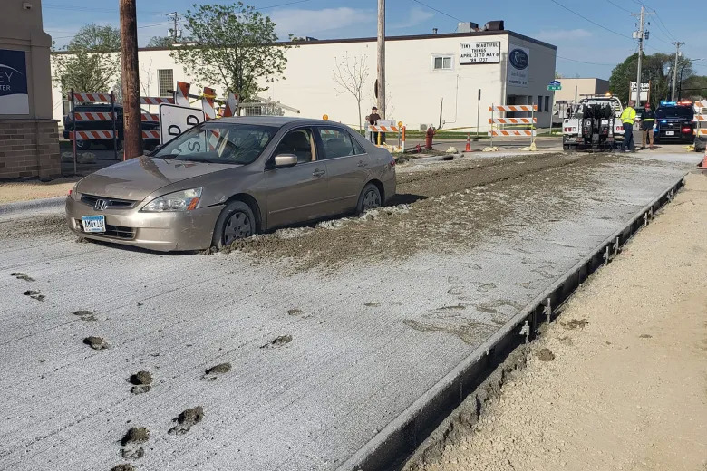 Minnesota woman caused $40,000 worth of damage after she drove through a barricade and got stuck in wet concrete.