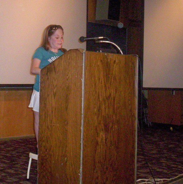 Mal speaking at a podium